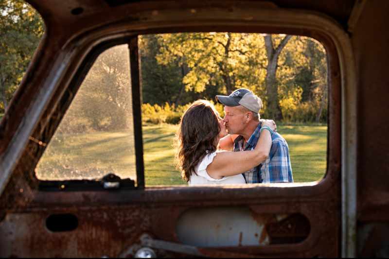 Couple kissing framed through a vintage truck window