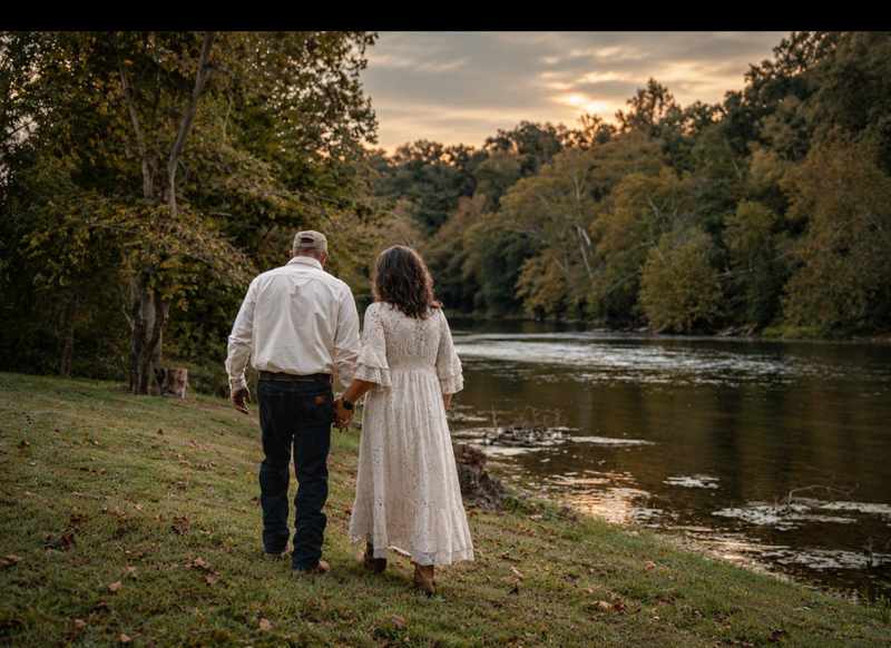Couple walking hand in hand beside the river