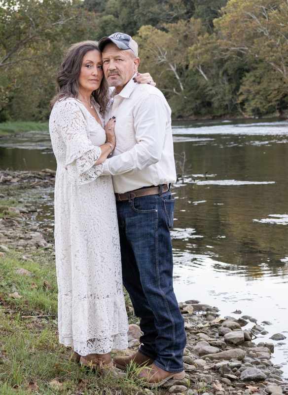 Anniversary couple posed together by the river